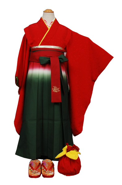 七歳祝い着セット 着物は赤地、袴は緑(刺繍の背紋がついた袴姿)